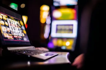 Uma mulher sorrindo perto de máquinas caça-níqueis brilhantes com símbolos de sorte, mostrando as emocionantes opções de slots do 7GAME SBET.