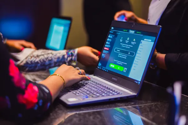 Um dealer confiante cercado por fichas de cassino convidando jogadores a acessar sua conta 7GAME SBET, refletindo opções de login rápidas e fáceis.